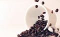 Image shows an upturned cup of coffee beans, representing some of the effects of caffeine on our mood.